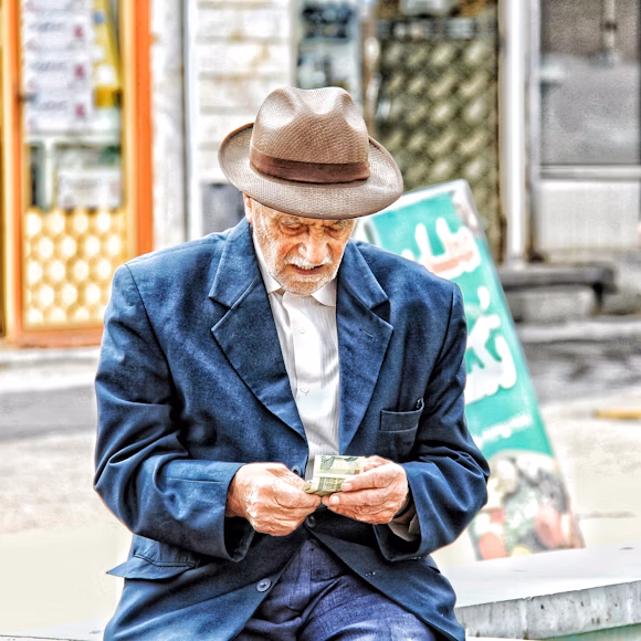 Senior man calculating his retirement budget affected by the Réforme des pensions and its social impact"