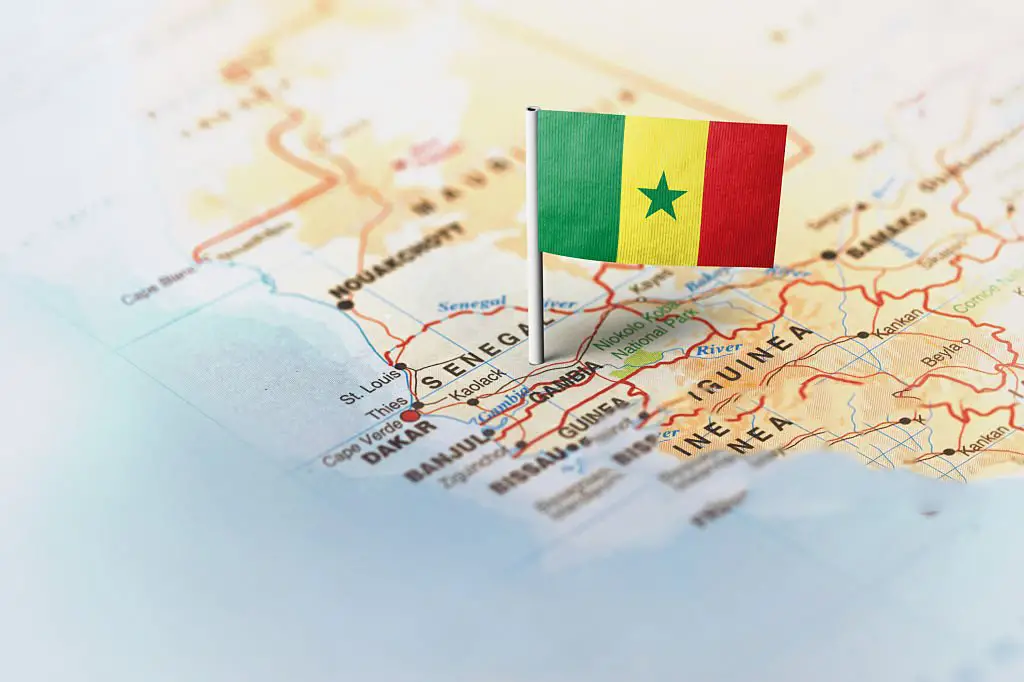 Le drapeau du Sénégal épinglé sur la carte. Orientation horizontale. Photographie macro.